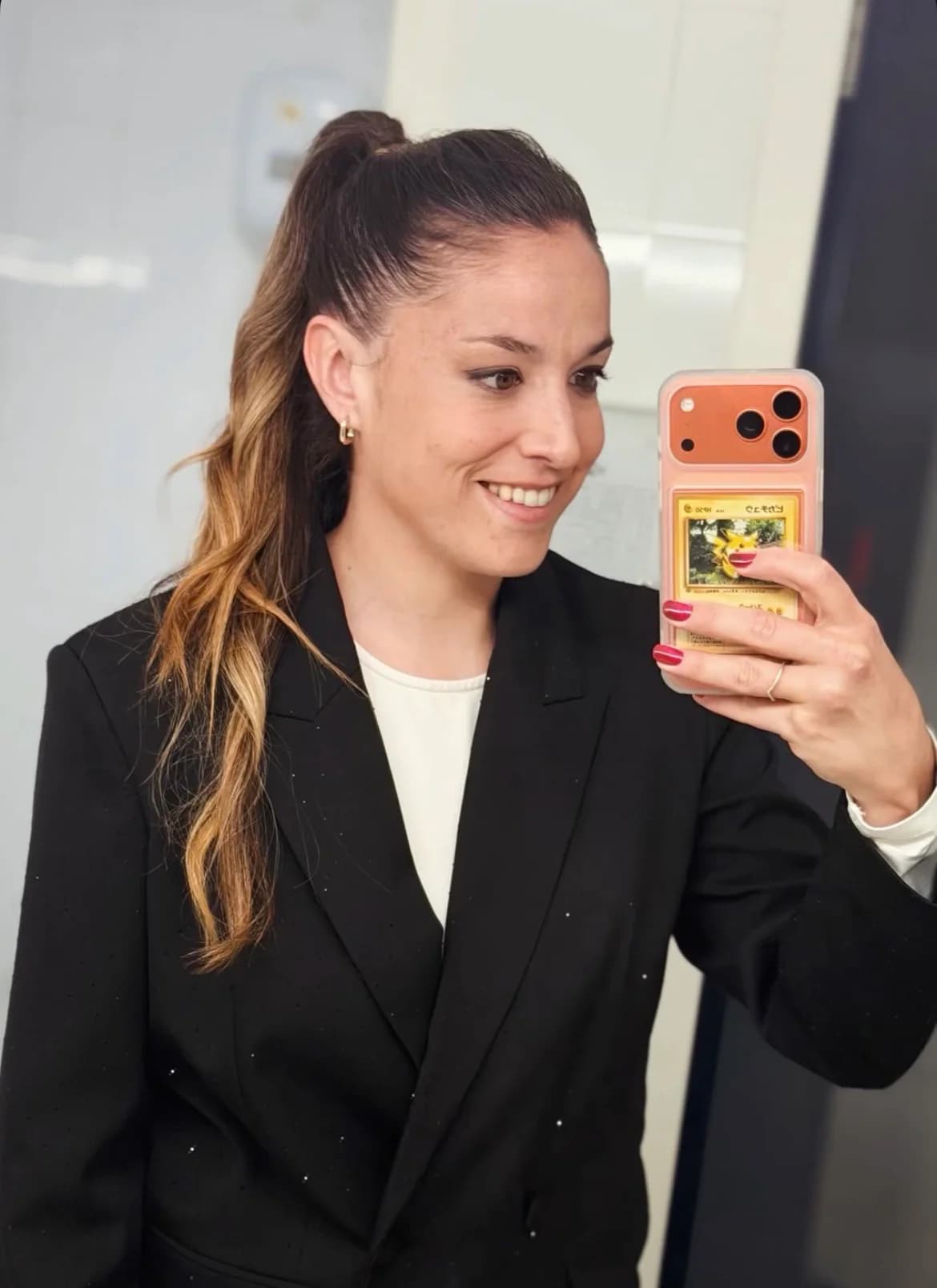 Selfie avec iPhone orange et carte Pikachu dans la coque