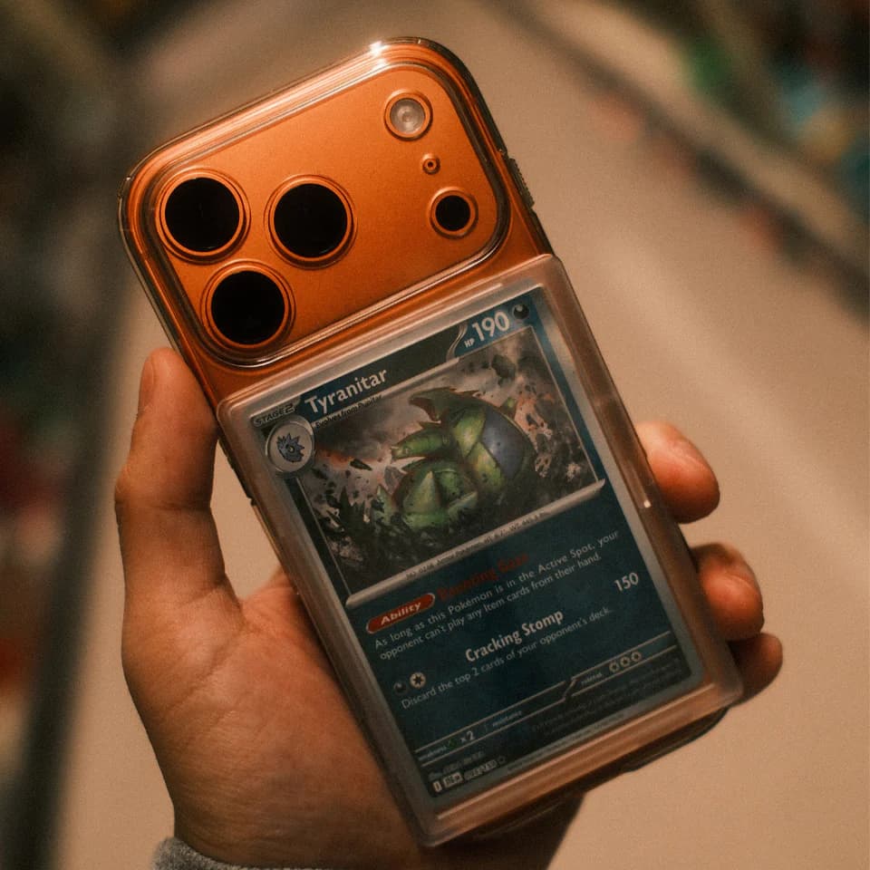 Mag Snap tenu en main avec carte Tyranitar sur iPhone orange