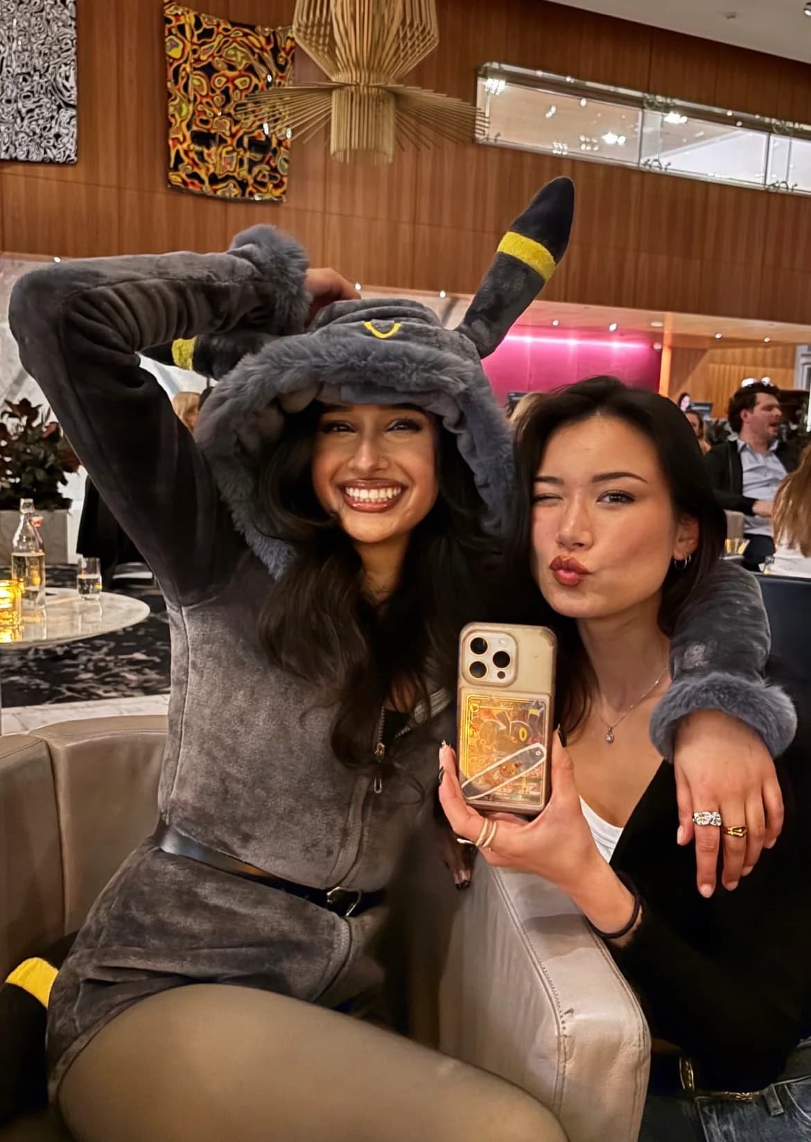 Deux amies avec coque Umbreon et carte dorée